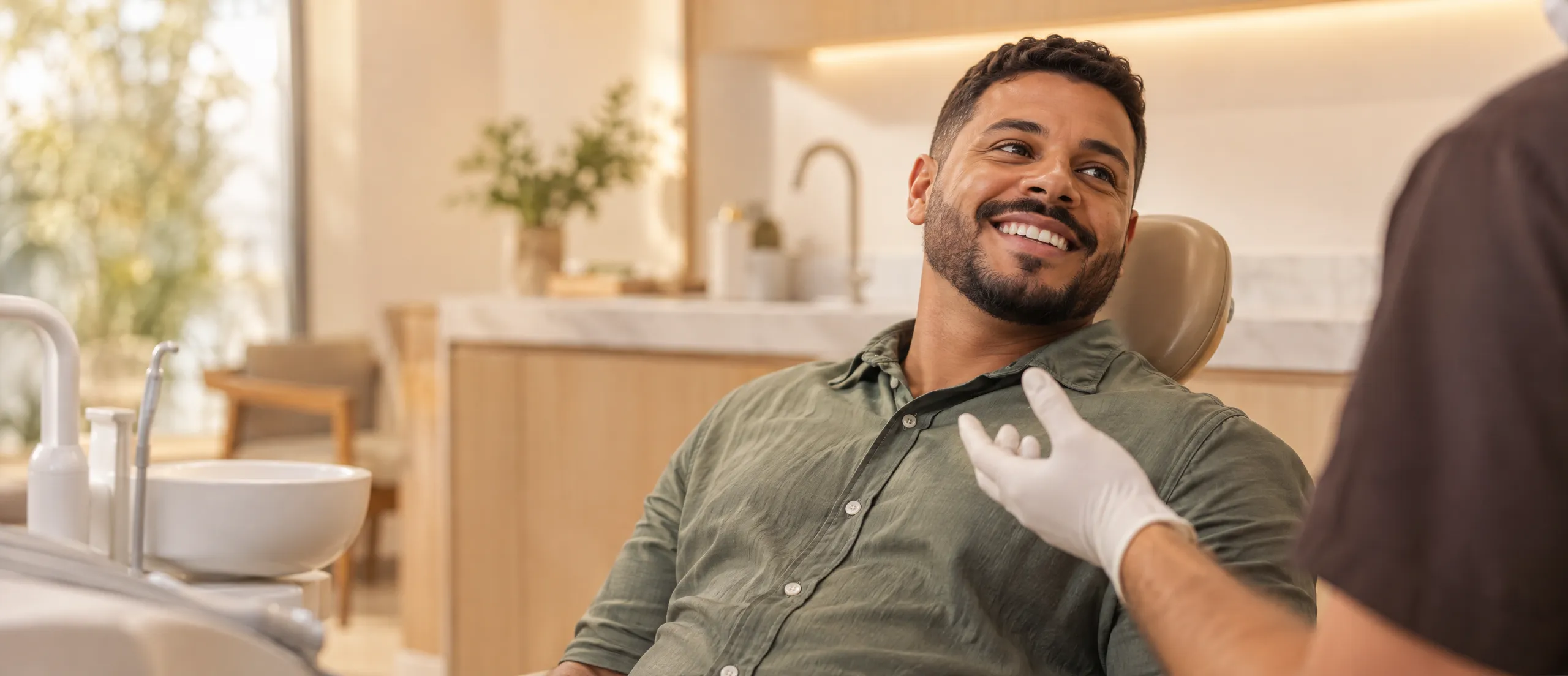 Paciente sorrindo na cadeira odontológica durante uma consulta de rotina