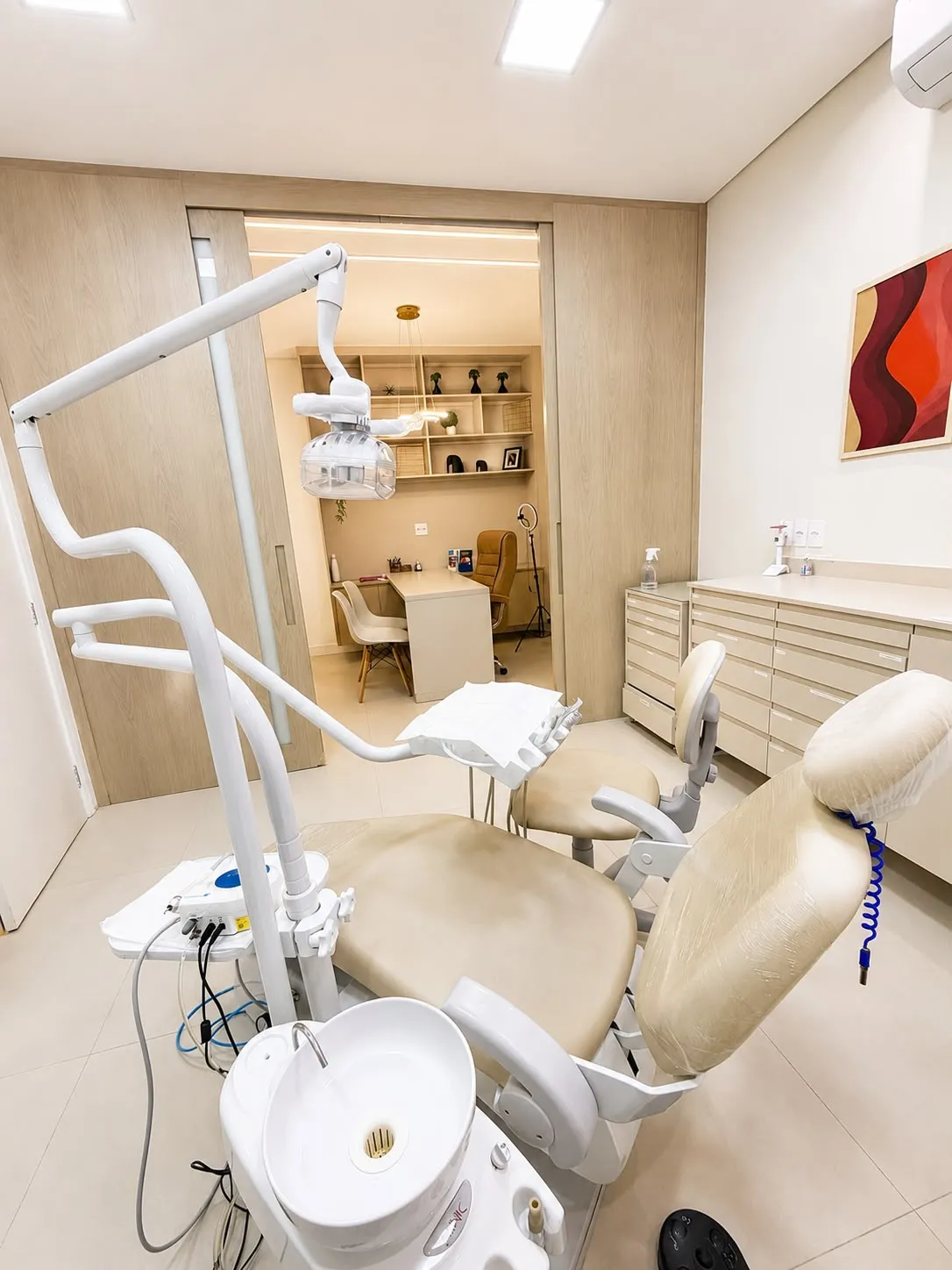 Consultório da OroImplante com cadeira odontológica e armários em madeira clara